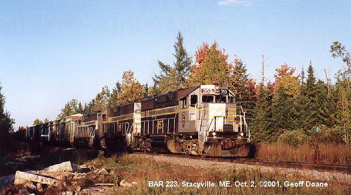 Photo of BAR 223 passes an old freight shed in Stacyville, ME.