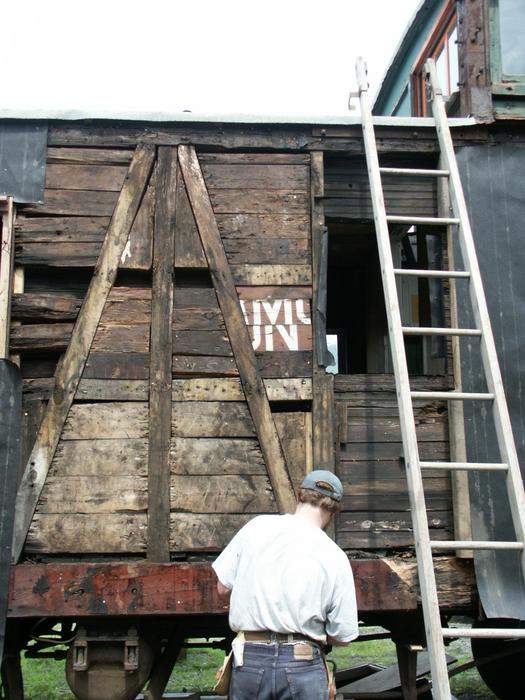 Photo of SFTM caboose during restoration showing bits of old boxcar wood