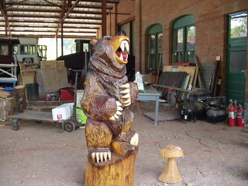 Photo of wood figure of bear behind visitor center