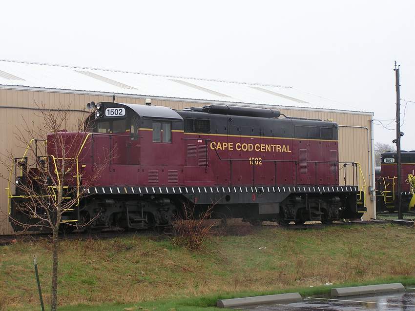 Photo of Cape Cod Central #1502 sitting in the rain behind the Hyannis Engine House