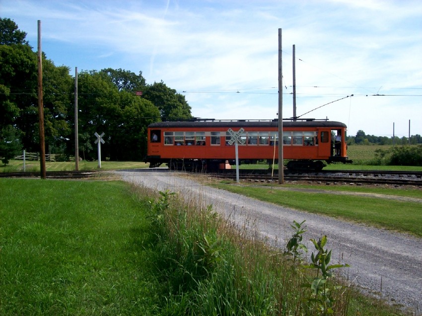 Photo of The NYMT trolley #161 crosses the dirt road in Rush ny non its way to the RG&V.