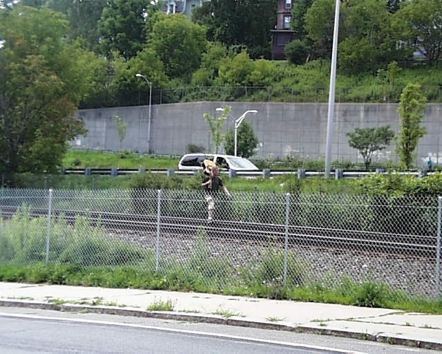 Photo of guy walking the railroad tracks at pittsfield ma a train behind him
